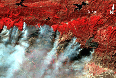 Images taken in two different infrared wavelengths reveal different details of a smokey fire, demonstrating that a fire-spotting satellite could see ignition sites obscured by smoke. These images are of a 2003 fire in the San Bernardino National Forest near Los Angeles, taken by the ASTER satellite.