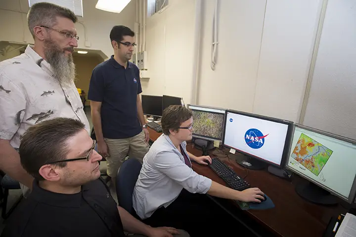 Idaho State University / NASA team in GIS Center, from left, sitting, Zachery Simpson, and Jenna Williams; standing, Keith Weber and Jeff May. Photo credit: ISU