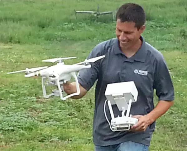 Curtis Moore of Apis Remote Sensing Systems in Hays, Kan., retrieves one of the small Unmanned Aerial Systems demonstrated during the Colby event. (Terry Anderson/Midwest Producer) Credit: Midwest Producer