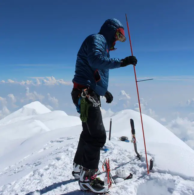 Blaine Horner of CompassData probing the snow pack at the highest point in North America along with setting up Global Position System equipment for precise summit elevation data. (Photo: Blaine Horner, CompassData)