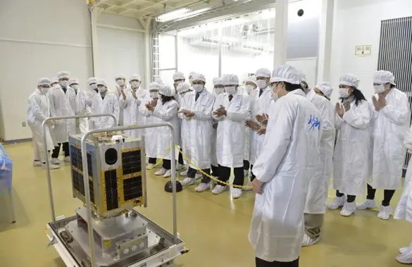 Filipino scientists and engineers with their Japanese counterparts look at the completed Diwata-1. Credit: Philippine Microsatellite Program